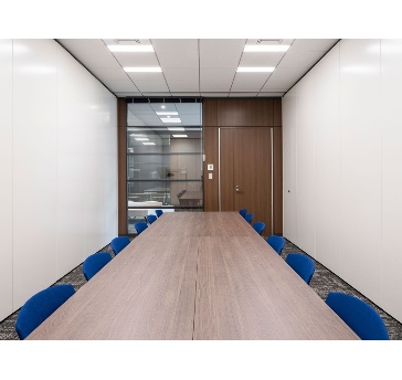 ホワイエ側を全面ガラスウォールとしているため、閉塞感がなく、ゆとりを感じられる設計です。入り口付近は落ち着いた木目調のパネルと扉で構成されており、外からの光を感じつつ、機密性を保った打ち合わせが可能です。