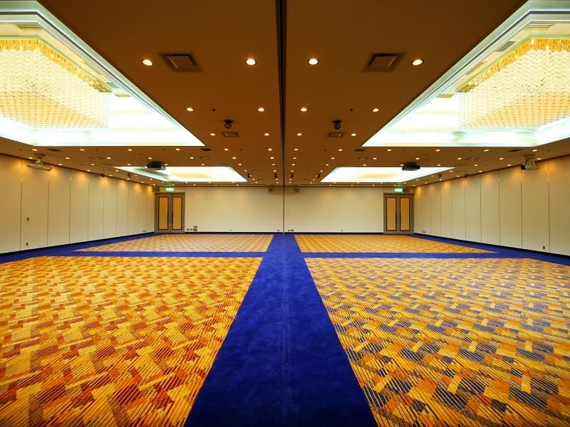 宴会場【桜島】2分割可
縦19ｍ✕横19ｍ✕高さ3.5ｍ　面積361㎡
会場には150インチの電動スクリーン2基、9,800ルーメン
のプロジェクター2基完備。
高速インターネット対応（有料）