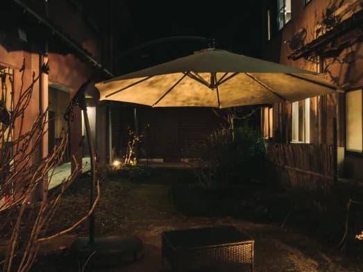 【中庭】
夜の灯りに包まれた、温泉旅館の静かな中庭。