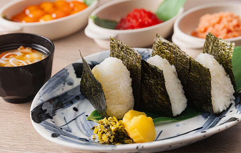 【 朝食 】
朝食会場にて、お客様のオーダーを受けてから心を込めて ”むすび” ます。
具材やお米など素材にこだわっており、オススメの一品は 「 卵黄醤油漬け 」 です。
仕込みに30時間をかけ、醤油ベースのオリジナルのたれに漬けこんでおりとろっとろの食感が魅力です。