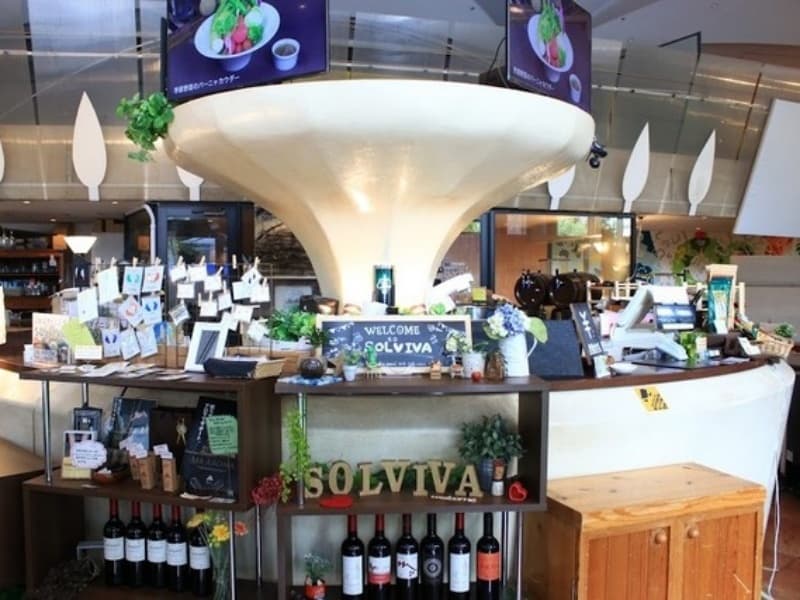 「WELCOME SOLVIVA」のサインが置かれた受付・バーカウンターエリア。ワインボトルや装飾品が並び、ゲストを迎える演出が充実しています。