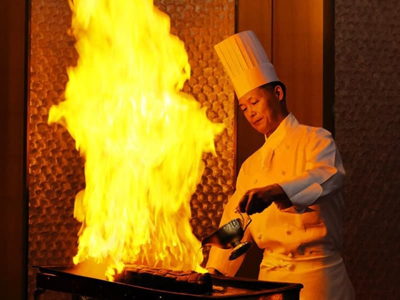 【シェフによる料理の演出】
ホテルオークラ神戸では「料理で魅せる」演出も行っています。ローストビーフを仕上げる際、パーティ会場でシェフが鮮やかな手さばきで行うフランベもそのうちの一つです。盛大に上がる炎とともに会場全体に漂う香りと音、そして目の前で切り分けできたてをお召し上がりいただくローストビーフは、お客様からご好評いただいております。