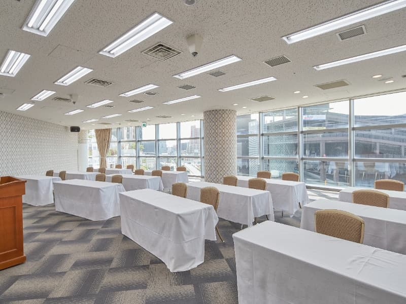 5F MEETING ROOM（ミーティングルーム） 107㎡
スクール形式 1卓2名掛：32名様／1卓3名掛：48名様

大きな窓からあたたかな光を感じる「ミーティングルーム」。
会議やセミナーなどに、開放的な空間でゆったりとしたお時間をお過ごしいただけます。