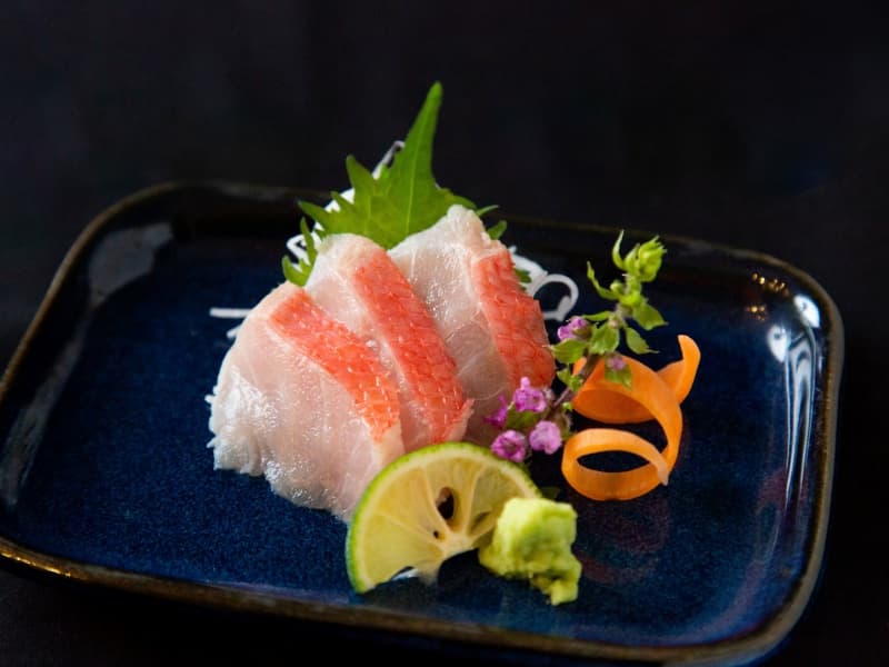店主が厳選した旬の魚の刺身。透き通るような白身の美しさと、上品な甘みが際立つ一皿は、旬の食材へのこだわりを感じさせます。