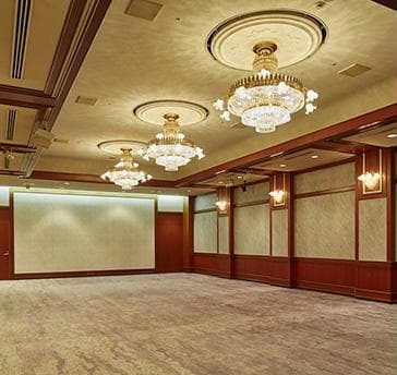 中宴会場【コンチネンタル】170㎡
着席：70名様　立食：110名様
ダークブラウンの天然木をアクセントに、華やかなシャンデリア、ブラケット照明を備えたヨーロッパの邸宅を思わせる落ち着いた雰囲気の宴会場です。