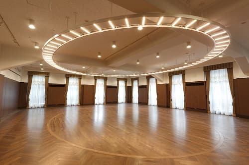 ホール1
・大きな窓と高い天井、サークル型の照明が特徴です。
・会議、セミナー、接待、会食等にもお使いいただけます。
・別途オプションにて、マイク、プロジェクター、スクリーン等もご用意しております。
・立食　最大60名　　　・着席　最大48名
面積153.02㎡　　　天井高3.35メートル