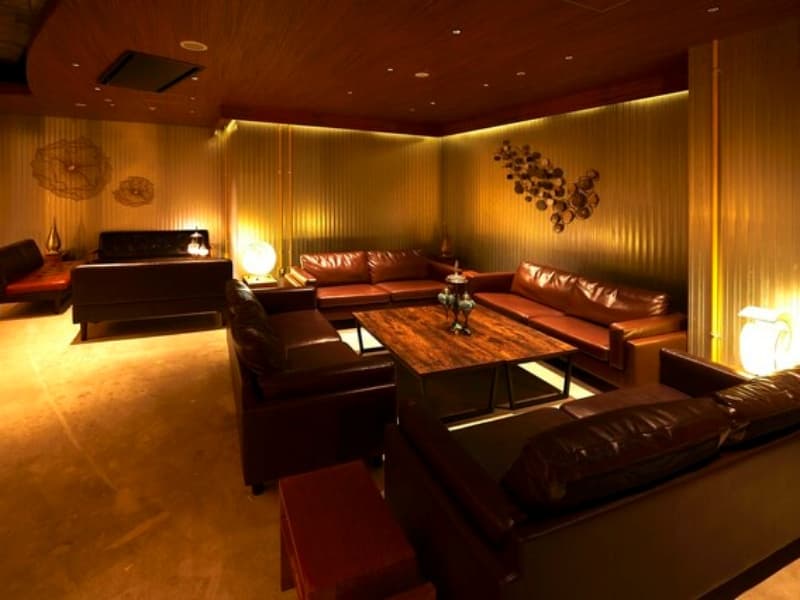 ゆったりとしたソファ席と温かみのある間接照明が印象的な、落ち着いた大人な雰囲気の店内。