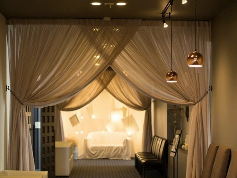 柔らかなドレープカーテンと温かみのある照明が幻想的な雰囲気を醸し出す空間。非日常の世界へと誘う、特別なひとときにふさわしいしつらえです。