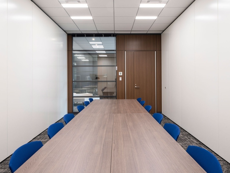 ホワイエ側を全面ガラスウォールとしているため、閉塞感がなく、ゆとりを感じられる設計です。入り口付近は落ち着いた木目調のパネルと扉で構成されており、外からの光を感じつつ、機密性を保った打ち合わせが可能です。