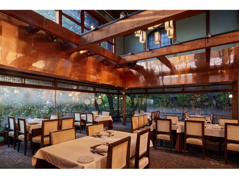 【バンケット-AKAGANE-】
吹き抜けの天井が開放的なダイニングルーム。窓からはお庭の緑が眺められ、ディナータイムにはライトアップも。
●最大卓数：スクエア9卓（1卓4~12名様）
●収容人数：着席72名様/立食80名様
●面積：100㎡