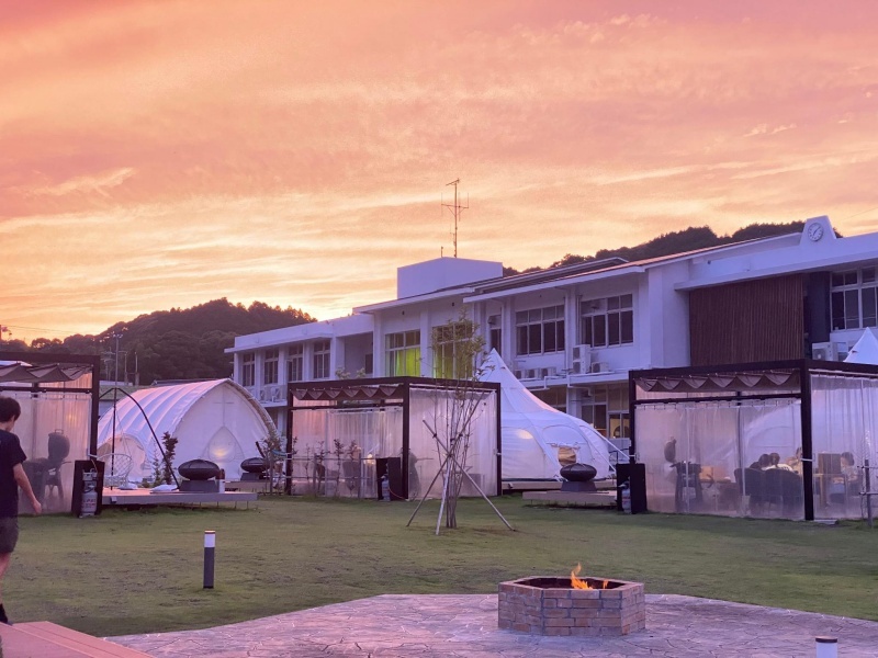 夕焼けに染まる空のもと、焚き火を囲む特別なひととき