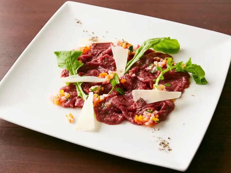 上質な馬肉が入った時に登場する日替わりメニュー「馬肉のカルパッチョ」。柔らかな赤身肉に、イタリア伝統の野菜ソース、カンパニョーラソースを添えました。肉の濃厚な旨みとコクに、野菜たっぷりのさっぱりソースが調和します。