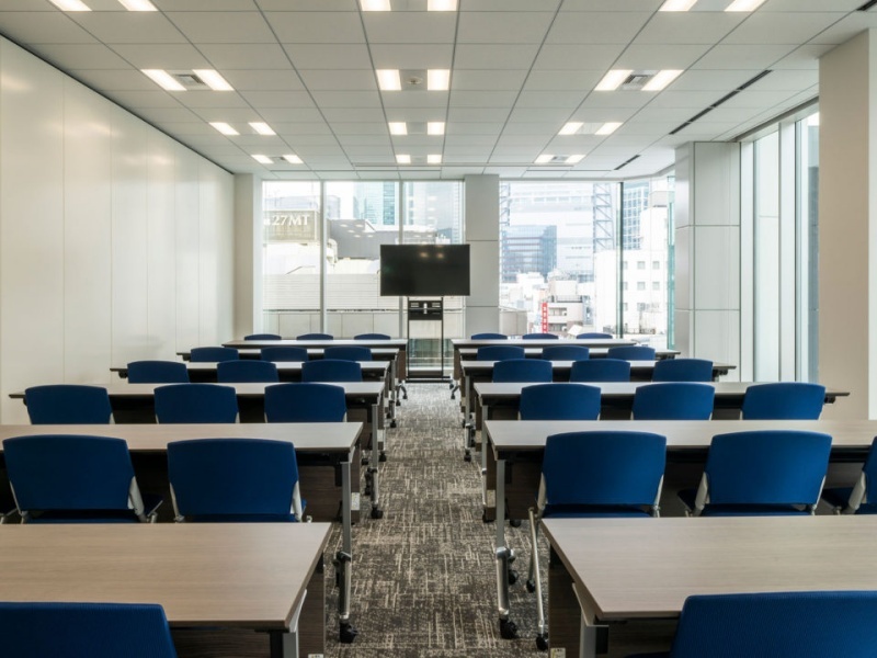 プレゼンテーションに最適な、大型モニターと演台を備えた正面エリアです。 音響調整装置やワイヤレスマイクも無料設備として整っており、スムーズな進行をサポート。 白を基調とした洗練されたデザインが、登壇者を引き立て、質の高いイベントを実現します。