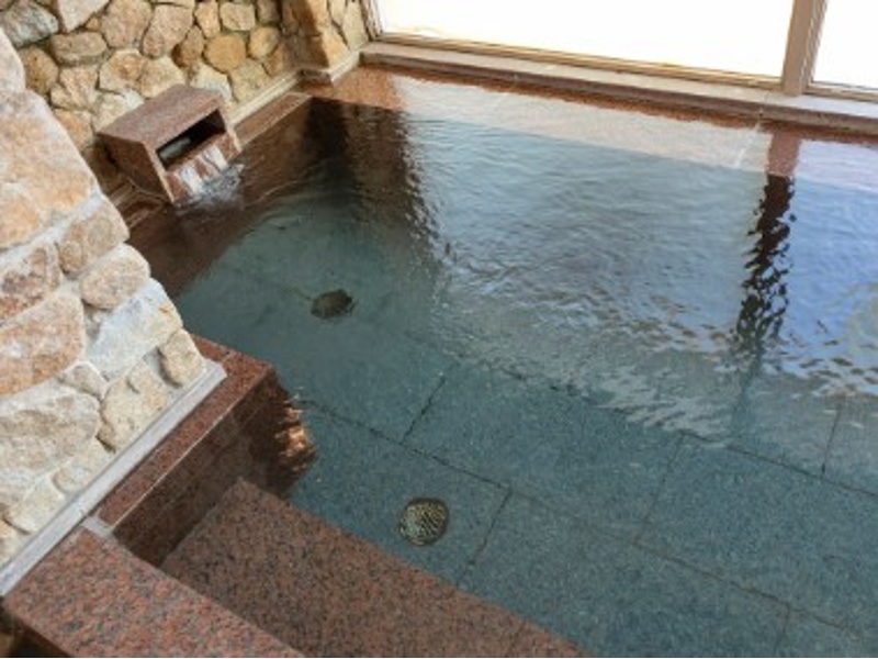石造りの湯船が落ち着きを添える内湯。
