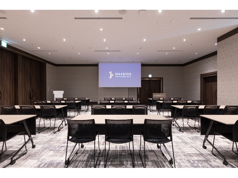 Link Room 2(最大94名)
40-50名規模の会議・セミナーに最適です。正方形に近い形状のため、ロの字・コの字スタイルも作りやすく、どの席からでも前方のスクリーンを近くで見ることができます。