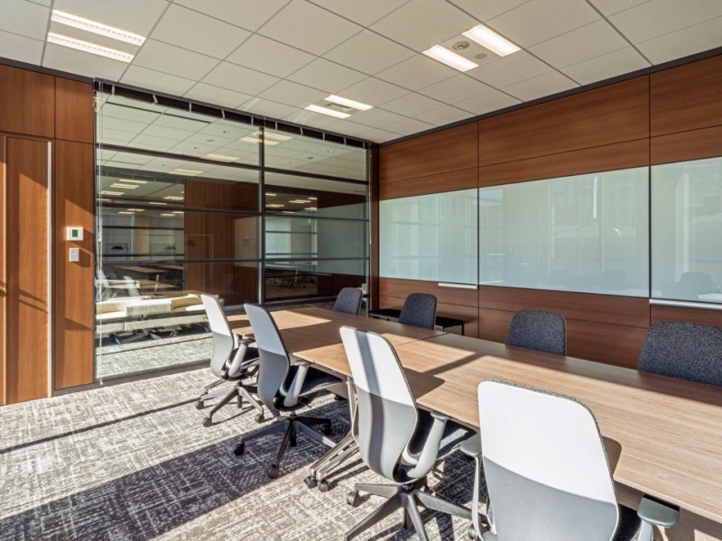 木目調の壁面が落ち着いた空間を演出し、重要な商談や採用面接にも適した静かな環境です。大型モニターとは別にホワイトボードも備わっているため、デジタルとアナログを使い分けた効率的なミーティングが可能です。