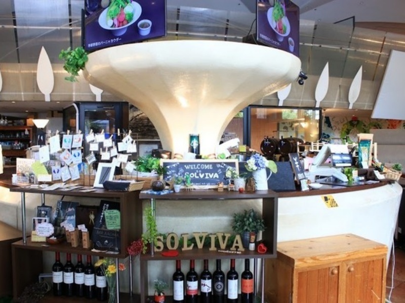 「WELCOME SOLVIVA」のサインが置かれた受付・バーカウンターエリア。ワインボトルや装飾品が並び、ゲストを迎える演出が充実しています。