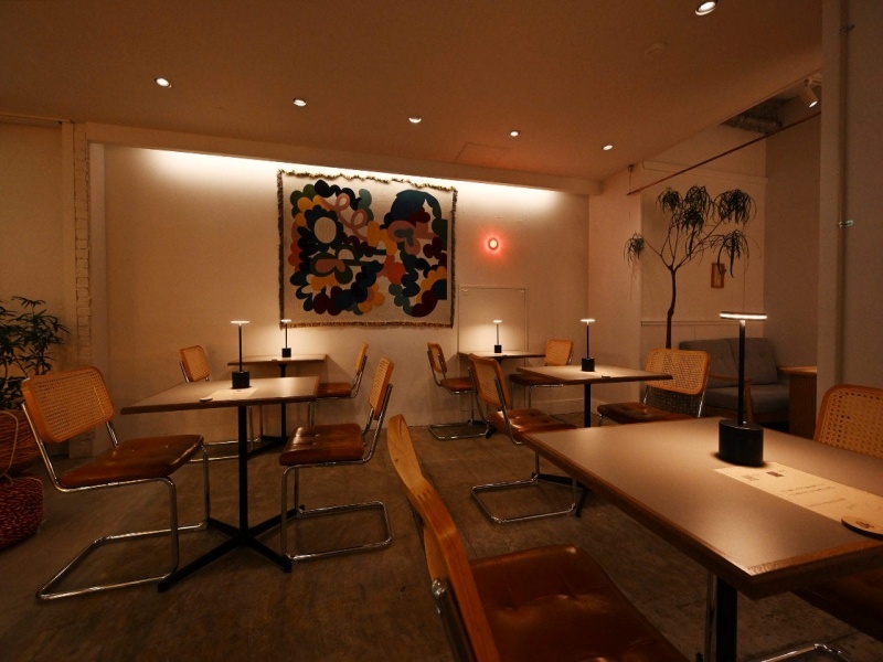 アートが灯りに照らされた、落ち着いた店内