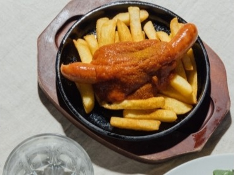 カレーケチャップの甘辛ソースをトッピングしたソーセージをフライドポテトと一緒にどうぞ。