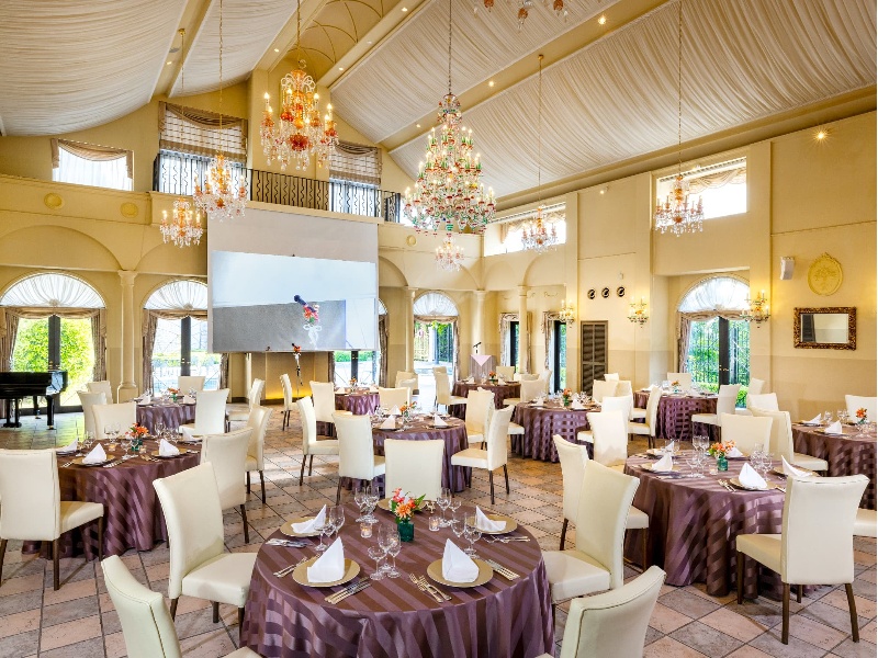 高い天井からドレープが弧を描く。やわらかいテイストのパーティ会場